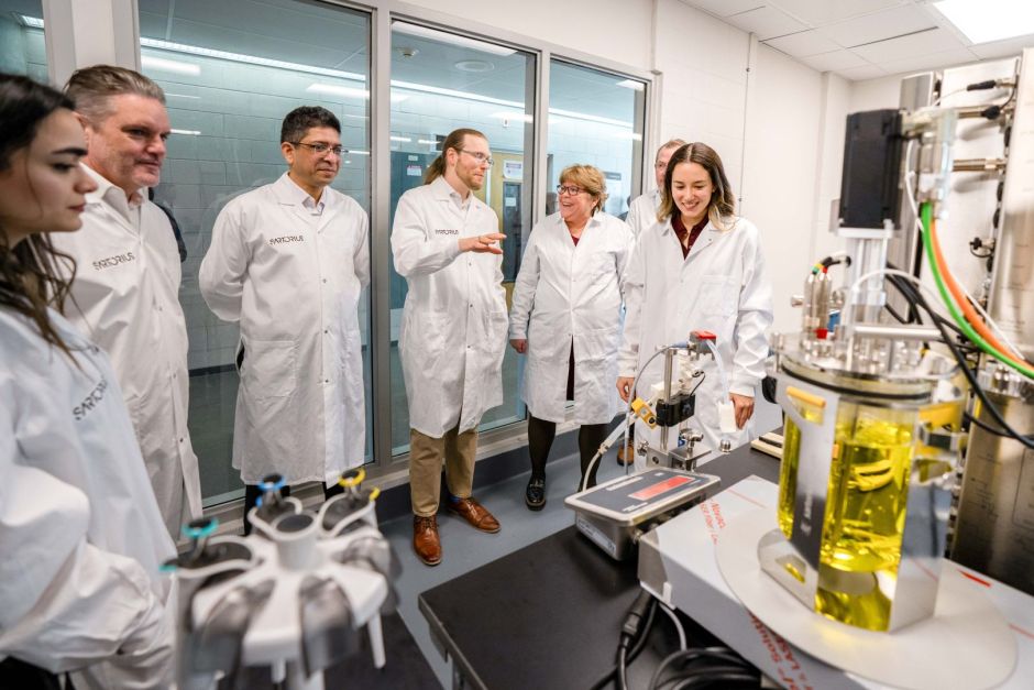 Studierende und Mitarbeitende in weißen Laborkitteln bei der Eröffnung des neuen Labors an der McMaster University