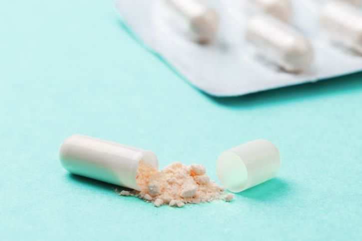 Geöffnete Tabletten Kapsel mit austretendem Pulver