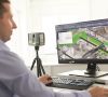 Mann vor Monitor mit Hand an der Maus und anderer Hand an der Tastatur